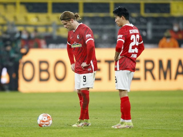 Lucas Holer dari Freiburg dan Jeong Woo-yeong terlihat berkecil hati setelah pemain Borussia Dortmund Erling Braut Haaland mencetak gol ketiganya pada 14 Januari 2022